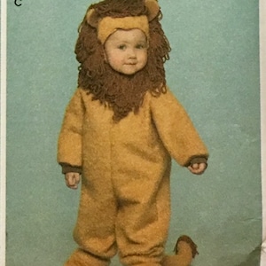 May include: Simplicity costume pattern for kids, featuring four different costume designs: a monkey, an angel, a frog, and a lion. The pattern includes sizes 1/2, 1, 2, 3, and 4. The costumes are in various colors.