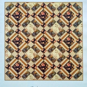 May include: A quilt pattern titled "Bird Cage" with a repeating diamond design. The quilt is 51 inches by 51 inches. The table runner is 51 inches by 17 inches. The pattern features floral and geometric patterns in shades of brown, cream, and burgundy.