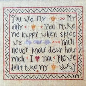 May include: Cross-stitch embroidery with a cream-colored background and a red and black border. The text reads "You are my only, you make me happy when skies, you'll never know dear how much I love you, please don't take my way."