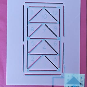 May include: A pink quilting template with the text "GI-2002" and "Flying Geese 2". The template features a design with numbered triangles and lines, along with a small sample of a finished quilt block.