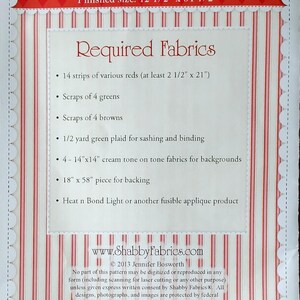 Op de afbeelding: Een naaipatroon voor een Patchwork Apple tafelloper. De afmeting is 31,75 cm x 138,43 cm. Het ontwerp heeft een rood-witte gestreepte rand en een rood ruitpatroon. Het patroon vermeldt de benodigde stoffen.