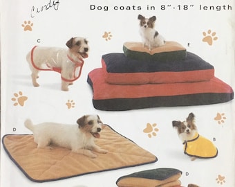 May include: Simplicity Crafts pattern for dog coats, sizes A, B, C, D, and E. The image shows various dog coats and beds, with dogs modeling the products. The pattern includes dog coats in 8"-18" lengths.