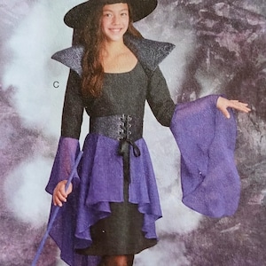 May include: A black and purple witch costume with a matching hat. The costume features a black bodice with a lace-up corset, a purple skirt, and long sleeves with flared cuffs. A witch's hat completes the look.