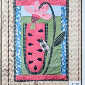 May include: A fabric panel with a watermelon-themed design. The panel features a pink watermelon with black seeds, a pink flower, and green leaves, set against a green and blue background. The text "Summer Days A 'Door' A Doodle" is at the bottom.