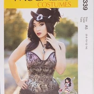 May include: McCall's Costumes pattern M7339. The image features a woman wearing a detailed corset and hat. The pattern size is A5, with measurements for sizes 6-8-10-12-14. The design includes a decorative corset with intricate patterns.