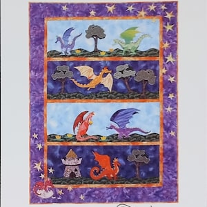 May include: A fusible applique pattern titled Little Dragons Everywhere! by Needlesongs. The cover features a quilt design with four horizontal panels depicting colorful dragons, trees, and a castle against a purple starry border.