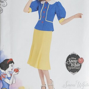 May include: Simplicity sewing pattern for a Snow White costume. The pattern includes a blue jacket with yellow trim, a yellow skirt, and a yellow hat with a red bow. The image also features the Disney Princess logo and the text "Snow White and the Seven Dwarfs".
