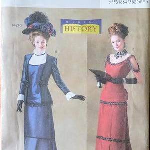 May include: A vintage Butterick sewing pattern, B4212, featuring two women in historical dresses. One dress is navy blue with white trim, the other is red. The pattern includes the text "MAKING HISTORY".