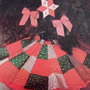 Pode incluir: Uma saia de &aacute;rvore circular com um design de patchwork de pain&eacute;is de tecido vermelho, verde e branco com motivos florais e estampados com uma borda franzida. Inclui um ornamento de estrela de cinco pontas e dois la&ccedil;os de tecido a combinar.