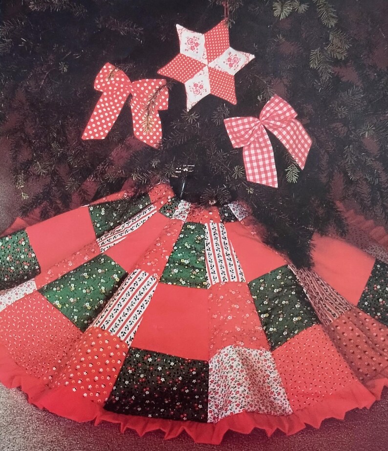 Pode incluir: Uma saia de &aacute;rvore circular com um design de patchwork de pain&eacute;is de tecido vermelho, verde e branco com motivos florais e estampados com uma borda franzida. Inclui um ornamento de estrela de cinco pontas e dois la&ccedil;os de tecido a combinar.