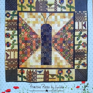 May include: A quilt pattern titled "The Painted Lady" featuring a butterfly design. The quilt uses a patchwork technique with various fabrics in shades of brown, blue, orange, and yellow. The border includes floral and fence motifs. The pattern is from Primitive Pieces by Lynda.