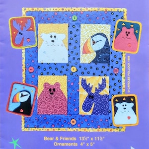 May include: A quilt pattern by Carolee Pollock featuring a central square with animal designs, including a bear, moose, and puffin. The quilt is 13.5" x 11.5", with ornaments measuring 4" x 5". The background is a vibrant blue with a yellow border.