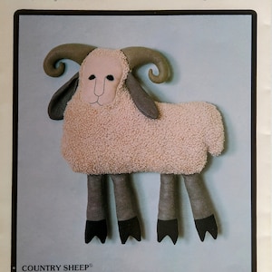 May include: A pattern for a Country Sheep stuffed animal. The sheep is beige with dark gray legs and horns. The pattern is approximately 21 inches by 24 inches high. The text on the pattern reads "That Patchwork Place" and "Country Sheep".
