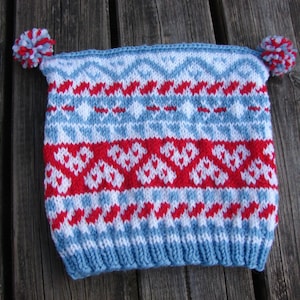 May include: A blue, white, and red knitted hat with a white pom-pom on each side.