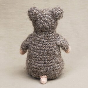 May include: A crocheted gray mouse toy with a pink nose and tail.