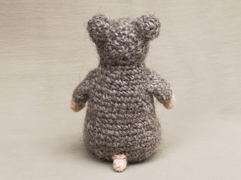 May include: A crocheted gray mouse toy with a pink nose and tail.