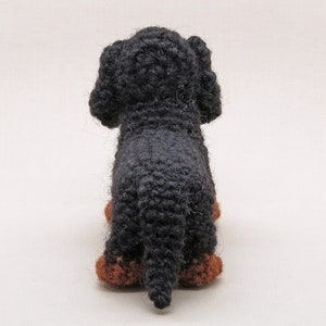 May include: A black crocheted dachshund toy with brown felt paws.