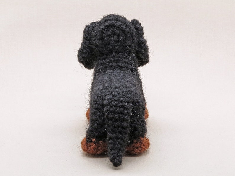 May include: A black crocheted dachshund toy with brown felt paws.
