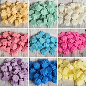 May include: Assortment of wax melts in various colors, including yellow, green, blue, pink, purple, and white. The wax melts are shaped like flowers and are arranged in a grid pattern.