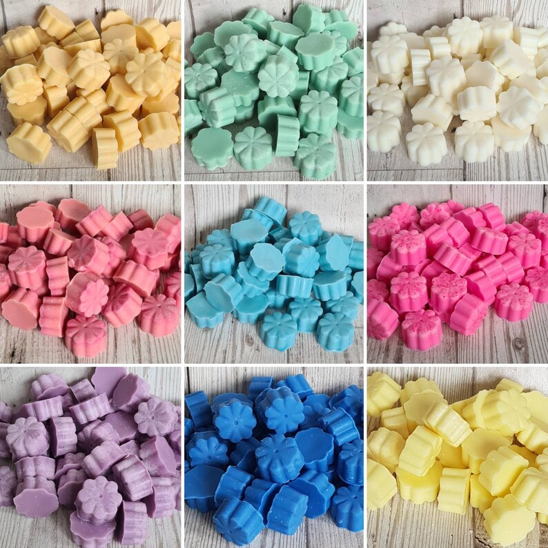 Pode incluir: Conjunto de ceras derretidas em v&aacute;rias cores e formas, incluindo amarelo, azul, rosa, roxo e verde. As ceras derretidas est&atilde;o dispostas em um padr&atilde;o de grade em uma superf&iacute;cie de madeira.
