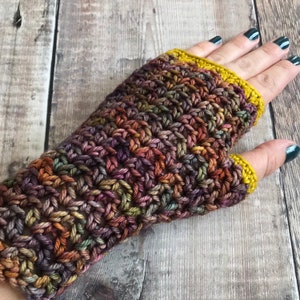 May include: Crocheted fingerless gloves in a multi-colored yarn with a yellow crocheted cuff.