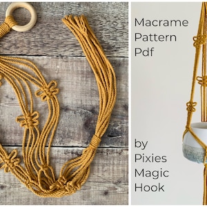 Puede incluir: Un macetero de macramé amarillo mostaza con un anillo de madera en la parte superior. El macetero está hecho con un patrón de nudos que se asemeja a una flor. El texto "Macrame Pattern Pdf by Pixies Magic Hook" es visible en la imagen.