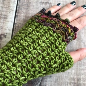 May include: Green crochet fingerless gloves with a colorful crocheted cuff.