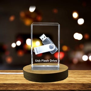 May include: A clear crystal cube with a 3D engraved image of a USB flash drive. The cube is on a wooden base and the text "Usb Flash Drive" is engraved on the base.
