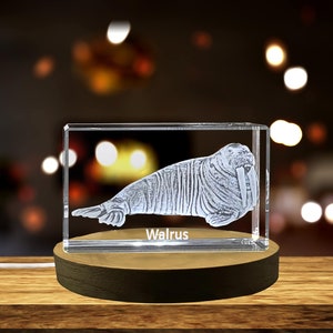 Puede incluir: Un cubo de vidrio transparente con una imagen grabada en 3D de una morsa. El cubo está sobre una base de madera y la palabra "Morsa" está grabada en la base.
