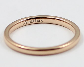 May include: A simple gold band ring with the name "Ashley" engraved on the inside.