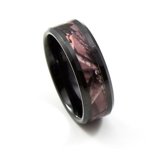May include: Black tungsten carbide ring with a camouflage pattern inlay. The ring has a beveled edge and a polished finish.
