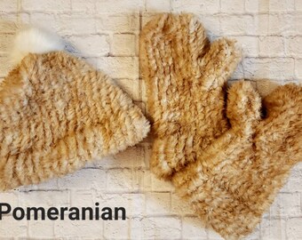 May include: A set of brown faux fur mittens and a matching hat with a white pom pom. The text "Pomeranian" is written below the items.