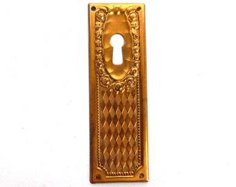 1 (ONE) Brass Stamped floral escutcheon, keyhole cover, with roses. #64CG6FK15