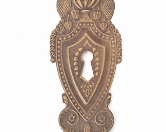 Antique Pressed Escutcheon, brass keyhole cover.
