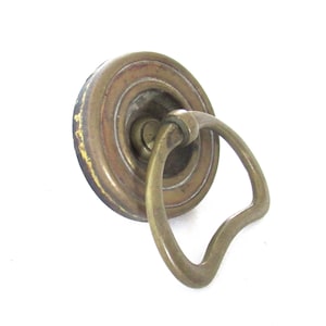 Peut inclure: Une poignée de porte en laiton avec une base ronde et une poignée en forme de D.