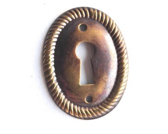 Small stamped keyhole cover, escutcheon, key hole frame, plate.