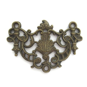 May include: Ornate antique bronze-toned drawer pull with a symmetrical design. The decorative hardware features scrolling details, a central leaf motif, and two loops for attachment. A vintage-style accent for furniture.