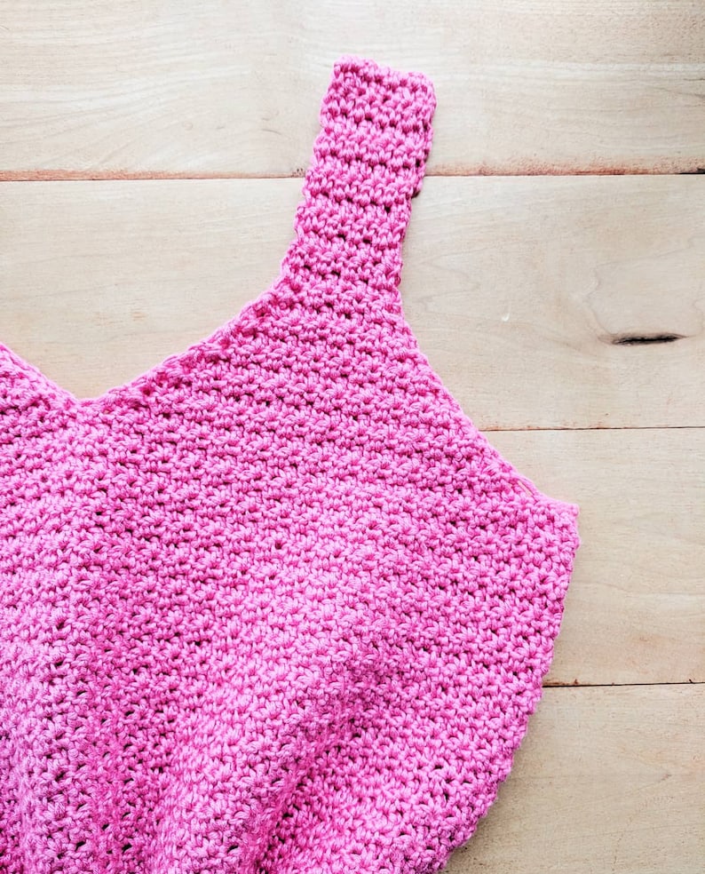 Peut inclure: Un d&eacute;bardeur en crochet rose avec un col rond et des bretelles fines.