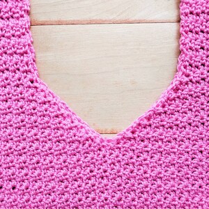 Peut inclure: Un haut en crochet rose avec un d&eacute;collet&eacute; en V. Le haut est r&eacute;alis&eacute; avec un motif de point simple et a une coupe d&eacute;contract&eacute;e.