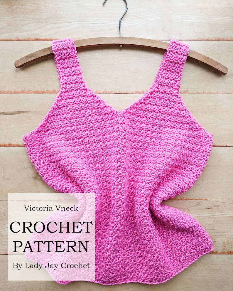 Peut inclure: Un patron de crochet pour un d&eacute;bardeur rose, suspendu &agrave; un cintre en bois. Le patron s'appelle "Victoria Vneck Crochet Pattern" par "Lady Jay Crochet".
