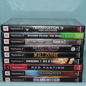 May include: A stack of ten PlayStation 2 video game cases. The games are: Terminator 3: Rise of the Machines, Syphon Filter: The Omega Strain, Tom Clancy's Rainbow Six 3, Medal of Honor: European Assault, Killzone, Commandos 2: Men of Courage, Red Faction, Headhunter: Redemption, and Kill Switch.