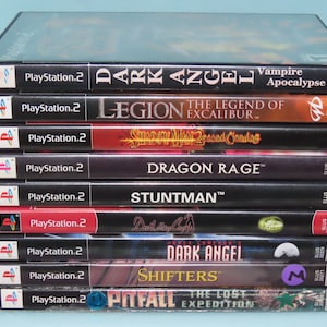 May include: A stack of ten PlayStation 2 video game cases. The games are: Dark Angel, Legion: The Legend of Excalibur, Shadow Man 2: Second Coming, Dragon Rage, Stuntman, Dark Angel, Shifters, Pitfall: The Lost Expedition.