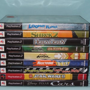 May include: A stack of ten PlayStation 2 video game cases. The games include: Looney Tunes Back in Action, Shrek 2, Herdy Gerdy, Avatar: The Burning Earth, Avatar: The Last Airbender, Nicktoons Unite!, SpongeBob Squarepants: Lights, Camera, Pants!, Lego Star Wars II: The Original Trilogy, and Disney Pixar Cars.