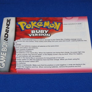 May include: A red and white Game Boy Advance game cartridge for Pokemon Ruby Version. The back of the cartridge has instructions on how to avoid battery leakage and how to properly insert and remove batteries.