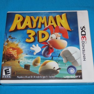 May include: A white Nintendo 3DS game case with a blue and yellow cover featuring the video game Rayman 3D. The cover shows Rayman running and jumping in a tropical setting. The game is rated E for Everyone by the ESRB.