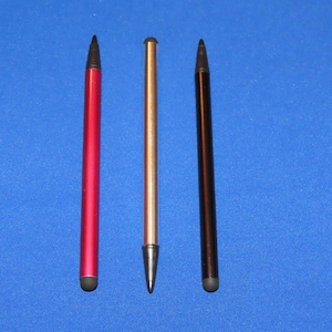 May include: Three stylus pens, one red, one silver, and one black, are lined up against a blue background.