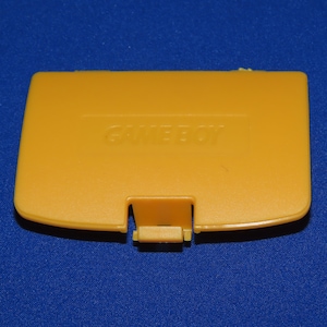 May include: A yellow Game Boy Color game cartridge case with the word "GAME BOY" printed on the front.
