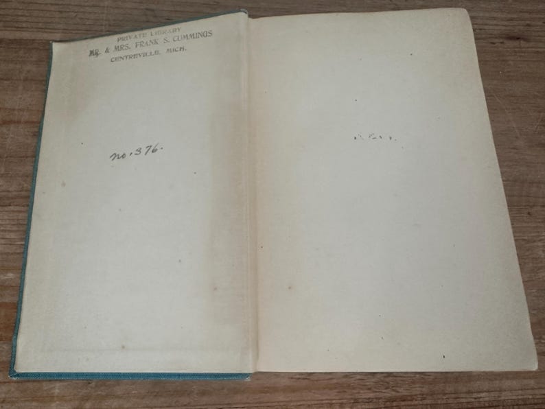 May include: Open book with aged, off-white pages. The left page has text: "PRIVATE LIBRARY, MR. & MRS. FRANK S. CUMMINGS, CENTERVILLE, MICH." and "no. 376." The book's cover is a faded teal color.