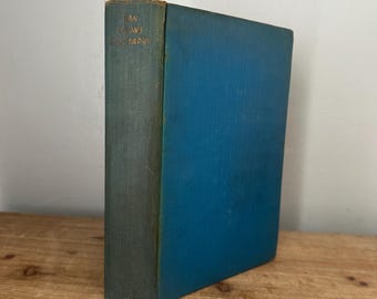 May include: A vintage book with a teal spine and a blue cover. The spine has gold lettering that reads "AN IONS GRAPHY". The book is standing upright on a wooden surface.