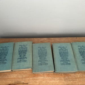 May include: Five vintage books titled "The Best of the World's Classics" are displayed on a wooden surface. The books have a teal cover with ornate text and design. The text includes the editor's name, Henry Cabot Lodge.